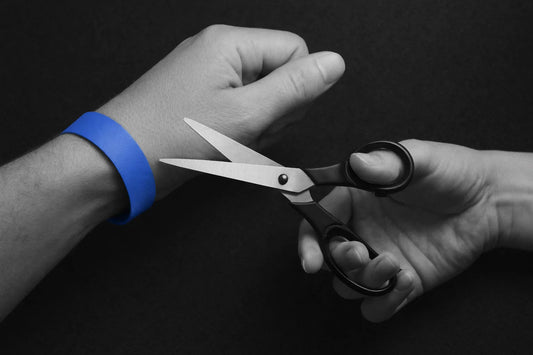 A paper wristband cut by scissors